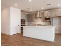 Modern kitchen with stainless steel appliances, a large island, and stylish gray cabinetry at 40218 N Alegre Dr, San Tan Valley, AZ 85140