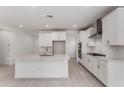 Bright kitchen with white cabinets, stainless steel appliances, a large island, and modern finishes at 40531 W Michaels Dr, Maricopa, AZ 85138