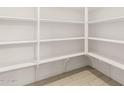 Walk-in pantry with multiple shelves and tile flooring at 40531 W Michaels Dr, Maricopa, AZ 85138