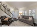 Bright living room featuring a staircase, gray sofa, black floors and shuttered windows at 4832 E Mineral Rd # 5, Phoenix, AZ 85044