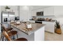 Bright kitchen featuring an island, stainless steel appliances, granite countertops, and white cabinetry at 514 W Freedom St, Florence, AZ 85132