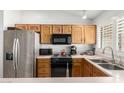 Functional kitchen with stainless steel appliances and wooden cabinets at 5658 E Fairbrook St, Mesa, AZ 85205