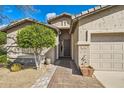 Inviting front entrance with a tiled walkway, desert landscaping, and an attractive exterior at 6198 W Wikieup Ln, Glendale, AZ 85308