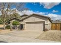 Home's exterior features an attached two-car garage and low-maintenance desert landscaping at 6198 W Wikieup Ln, Glendale, AZ 85308