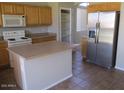 Bright kitchen with stainless steel refrigerator, wood cabinets, and tile floor at 6656 S Classic Way, Gilbert, AZ 85298