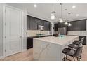 Modern kitchen featuring a large center island with sleek counter tops and stylish pendant lighting at 6931 W Spur Dr, Peoria, AZ 85383