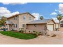 Charming two-story stucco home with manicured grass and multiple car garage under sunny blue sky at 7515 N 185Th Ave, Waddell, AZ 85355