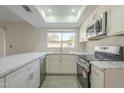 Modern kitchen with white cabinets, stainless steel appliances, and a sunlit window over the sink at 838 W Duke Dr, Tempe, AZ 85283