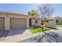 Exterior view of a home featuring a two-car garage, mature landscaping, and sidewalks at 1021 S Greenfield Rd # 1213, Mesa, AZ 85206