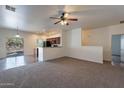 Inviting living room with plush carpeting, neutral walls, and open layout to kitchen and adjacent room at 1100 E Canyon Trl, San Tan Valley, AZ 85143