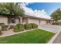 Lovely single-story home with a well-maintained lawn, attractive desert landscaping, and an attached three-car garage at 11069 E Kilarea Ave # 198, Mesa, AZ 85209
