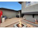 View of the outdoor entertaining space with gray pavers and a modern fire pit feature at 11652 N 49Th Dr, Glendale, AZ 85304