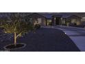 Dusk shot of landscaped front yard with accent lighting and circular driveway at 1455 E Dove Pl, Casa Grande, AZ 85122