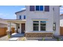 Inviting home exterior with brick accents, covered porch, and manicured landscaping at 14628 W Sand Hills Rd, Surprise, AZ 85387