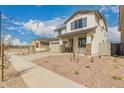 Inviting two-story home with stone accents, a two-car garage, and desert landscaping at 17032 W Fetlock Trl, Surprise, AZ 85387