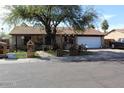 Ranch-style home boasts a well-maintained front yard, mature tree, and two-car garage at 17648 N 36Th St, Phoenix, AZ 85032