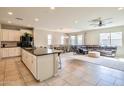 Open-concept kitchen featuring an island, modern appliances, and views of dining and living areas at 18187 W Via Montoya Dr, Surprise, AZ 85387
