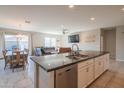 Bright kitchen with stainless steel appliances and island overlooking dining and living area at 18187 W Via Montoya Dr, Surprise, AZ 85387