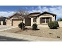 Attractive home featuring a three car garage, low-maintenance desert landscaping and shuttered windows at 18542 W Luke Ave, Litchfield Park, AZ 85340