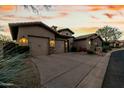 Stunning home exterior showing a well-manicured lawn and an attached three-car garage with stone veneer accents at 27708 N 110Th Pl, Scottsdale, AZ 85262