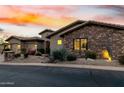 Lovely single-Gathering home with an attached three-car garage, desert landscaping, and inviting facade at sunset at 27708 N 110Th Pl, Scottsdale, AZ 85262