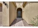 An arched entryway leads to the front door with stone pavers and desert landscaping at 32366 N 133Rd Ln, Peoria, AZ 85383