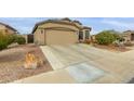 Single-story home with a two-car garage and desert landscaping at 42266 W Sparks Dr, Maricopa, AZ 85138