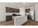 Modern kitchen with stainless steel appliances, granite countertops, a kitchen island, and dark wood cabinets at 619 W Pintail Dr, Casa Grande, AZ 85122