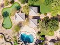 Stunning aerial view of lush backyard with putting green, cabanas and a sparkling free-form pool at 8260 N Buena Vista Dr, Casa Grande, AZ 85194