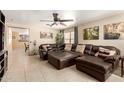 Spacious living room features a large sectional sofa, ceiling fan, and tile floors at 8520 E Laguna Azul Ave, Mesa, AZ 85209