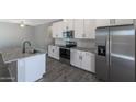 Well-appointed kitchen featuring stainless steel appliances, gray countertops, and stylish gray floors at 10329 N 115Th Ave, Youngtown, AZ 85363
