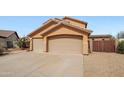Spacious three-car garage with a wide driveway and desert landscaping in a well-maintained neighborhood at 11263 S Oakwood Dr, Goodyear, AZ 85338