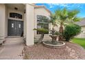 Elegant front entrance featuring a double door, stone walkway, mature palm trees, and a water feature at 1225 E Sea Gull Dr, Gilbert, AZ 85234
