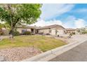 Inviting single-story home featuring lush landscaping, a fountain, and a spacious three-car garage at 13516 W Windsor Blvd, Litchfield Park, AZ 85340