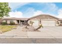 Attractive single-story home with a stone accents, three-car garage, and well-maintained desert landscaping at 13516 W Windsor Blvd, Litchfield Park, AZ 85340
