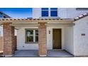 Home entrance showcasing brick columns, a covered porch, a dark-colored door, and a sidelight window at 14636 W Sand Hills Rd, Surprise, AZ 85387