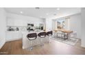 Modern kitchen with white cabinets, stainless appliances, and dining area at 14636 W Sand Hills Rd, Surprise, AZ 85387