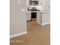 Partial view of kitchen area featuring stainless steel appliances and wood-style flooring at 21130 N 58Th St, Phoenix, AZ 85054