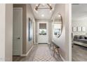 Bright hallway with wood floors, stylish light fixture, decorative mirror, and a glimpse into the bedroom at 4846 E Piccadilly Rd, Phoenix, AZ 85018