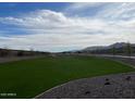 Lush green community park featuring a walking path, green lawn, and mountain views at 5839 W Willow Ridge Dr, Laveen, AZ 85339