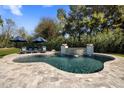 Gorgeous pool with stone tile, water features, lush landscaping, and lounge seating at 12755 N 99Th Pl, Scottsdale, AZ 85260