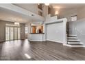Spacious living room featuring high ceilings, hardwood floors and stairs with bright white risers at 14333 W Lexington Ave, Goodyear, AZ 85395