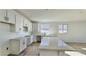 Bright kitchen featuring white cabinetry, stone countertops and a large island at 15748 W Beryl Ave, Waddell, AZ 85355