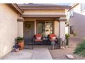 Inviting front porch with comfortable seating and decorative elements, potted plants, and a gated entrance at 1623 W Quick Draw Way, San Tan Valley, AZ 85144