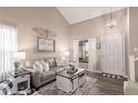 Bright living room with high ceilings, wood floors, neutral walls, stylish furniture, and natural light at 1623 W Quick Draw Way, San Tan Valley, AZ 85144