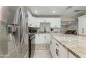 Bright kitchen features an island with bar seating, stainless appliances, and white cabinetry at 1716 N 32Nd Pl, Phoenix, AZ 85008