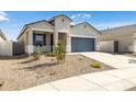 Beautiful single-story home featuring manicured desert landscaping, inviting curb appeal and a gray garage door at 17813 W Mission Ln, Waddell, AZ 85355