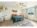 Bright bedroom featuring a ceiling fan, a large window, and decorative wall hangings at 1821 W Vermont Ave, Phoenix, AZ 85015