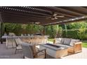 Outdoor living space with a covered patio, bar seating, a cozy fire pit, and comfortable seating at 20311 E Stonecrest Dr, Queen Creek, AZ 85142
