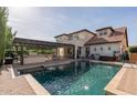 Backyard oasis with a sparkling pool, covered patio with a grill, and lounge chairs for relaxation at 20311 E Stonecrest Dr, Queen Creek, AZ 85142